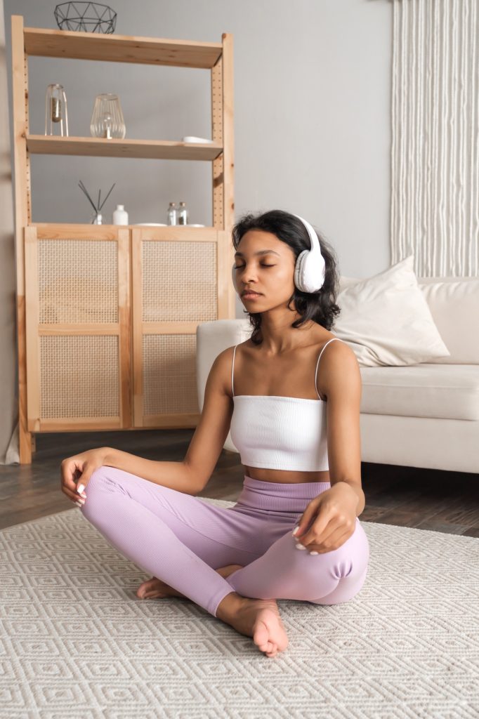 Mental wellbeing concept.Vertical banner with african american woman at home listening to music